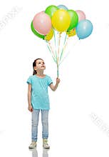 Girl looking up with bunch of helium balloons