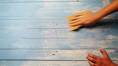 An accelerated footage of a person polishing the wooden board with sandpaper in order for it to look older