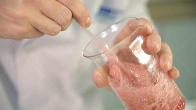 The laboratorian is checking the quality of soap base