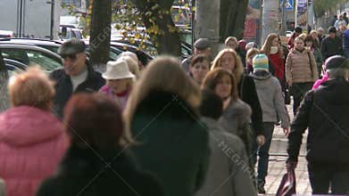A crowd of people are walking around town