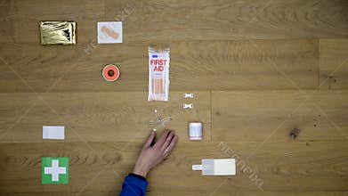 First Aid Kit being laid down on a wooden surface