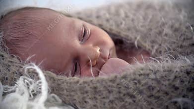 Baby all covered up in brown warm woollen cover