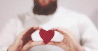 Bearded man hands holding Heart shape Love and Health symbol