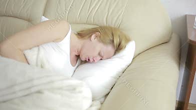 Woman with abdominal pain lying on the sofa. Girl drinking pills painkiller