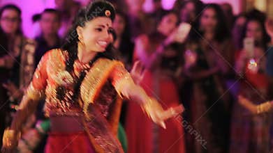 Stunning Indian bride in sari dances with guests