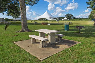 A concrete picnic table and canopies in a park
