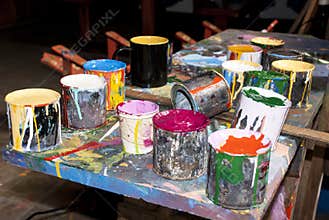 Paint bottles, brushes and paint cans