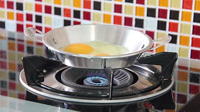 Egg Crack And Drop Into An Iron Pan, Where It Starts Frying On A Gas Stove.