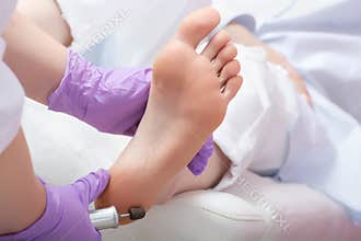Peeling feet pedicure procedure with eletric device in the beau