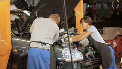 Engineers working with car engine