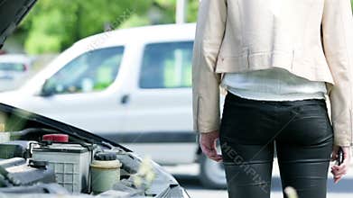 Woman with broken car waiting for help