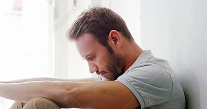 Sad man sitting on the floor