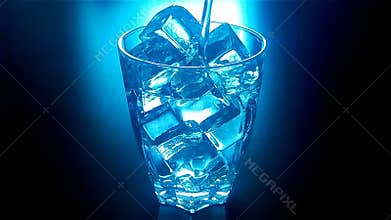 Pouring glass of water with ice cubes with blue backlit in slow motion at 120fps