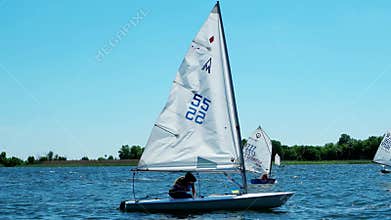 Competition sailing, rowing, local regatta on the river, a lot of boats appear before the audience, boats with sails,