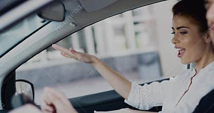 Happy young hipster couple dancing and singing like crazy in car driving