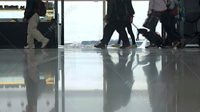 People With Luggage Passing By The Window In Airport