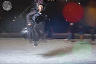 Fashion asian woman like witch flying above ice rink