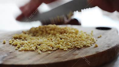 Artisan chef dicing almond confectionery on authentic chopping board