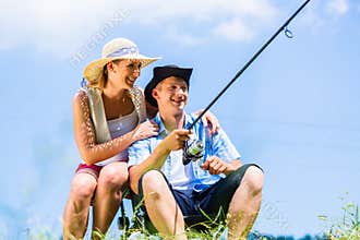 Man with fishing rod angling at lake enjoying hug