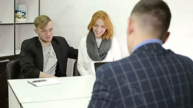 Young businessman talking with clients at office.