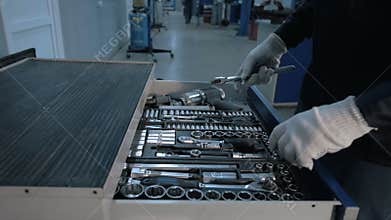 Mechanic open Blue Metal Box with Different Tools for Car Repair at Modern Service station