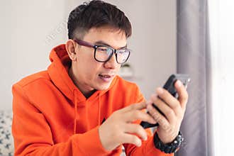 Young Asian happy while using smartphone chatting and making facetime video calling, lockdown situation. Social distancing concept