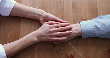 Female doctor caregiver stroking wrinkled hand of old man.