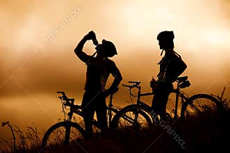 Mountain bike couple drinking in silhouette