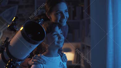 Happy girls learning astronomy and using a telescope