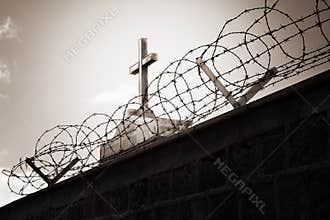 Religion and war - cross behind barbed wire