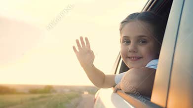 Happy girl kid child smile leaned out of a car window waving hand. Happy family travel journey concept. Daughter sister