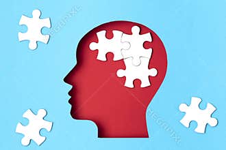 Papercut head with jigsaw puzzle pieces inside. Mental health problems, psychology, memory, logic, thinking process, solution,
