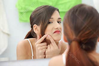 Young teenage woman with pimple