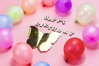 wooden letters forming happy birthday decorated with colorful ballons , holiday concept.