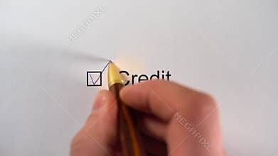 Man writing a tick in checkbox CREDIT on white paper. Credit Worthiness