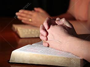 Man and Woman Praying with Holy Bibles