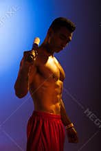 Sportive mixed race man with baseball bat on blue and dark purple gradient background