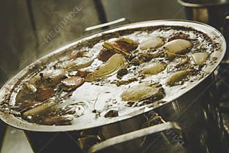 Beef broth boiling in a metal pot