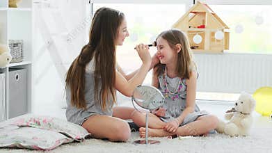 Beautiful girl friends putting makeup