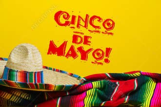 Mexican Serape blanket and sombrero on yellow background with Cinco de Mayo.