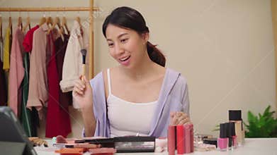 Slow motion - Beauty blogger present beauty cosmetics sitting in front camera for recording video. Happy beautiful young Asian