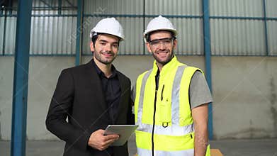 Portraits, engineers and Inspector stand smiling confidently in the warehouse.