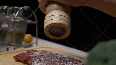 Рrofessional chef pepper meat steak. Close up slow motion