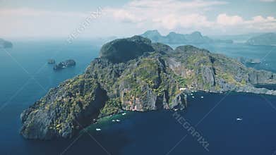 Tropic green forest mountainous island at ocean bay water aerial view. Sail boats at isle coast
