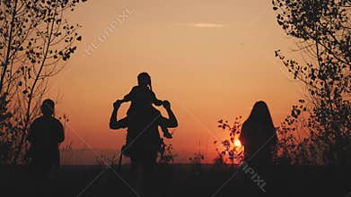 Happy family tourists go hiking in park sunset silhouette. Adventure travel concept. Teamwork. happy family a tourists