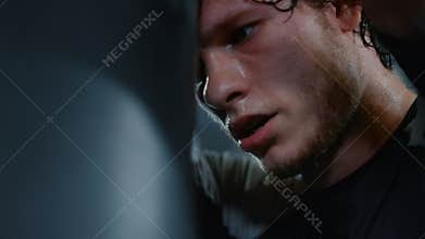 Tired fighter having break on ring. Sportsman leaning on bag in sport club