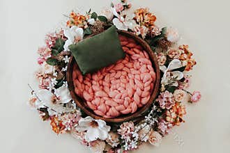 Newborn photography background - floral wreath on white background with wooden bowl and pink knitted chunky blanket knitted center