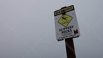 A sign at lighthouse point, Santa Cruz, warns surfers of danger, slippery rocks