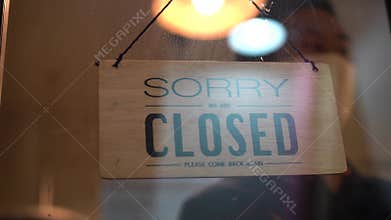 Man in face mask closing store during covid 19 lockdown, closing work, shutting business due to bankruptcy.