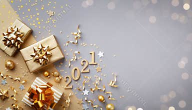 Golden gift or present boxes with golden bows, 2021 number and confetti top view. Christmas and New Year background. Flat lay.